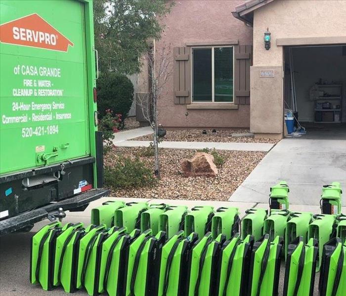 SERVPRO truck and drying equipment in front of house.